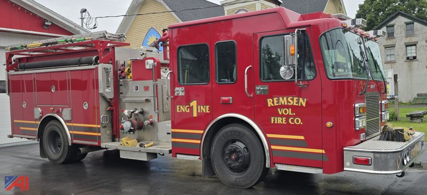 Fire truck cab with Remsen Vol. Fire Co. and engine text, red pumper with hoses and compartments.