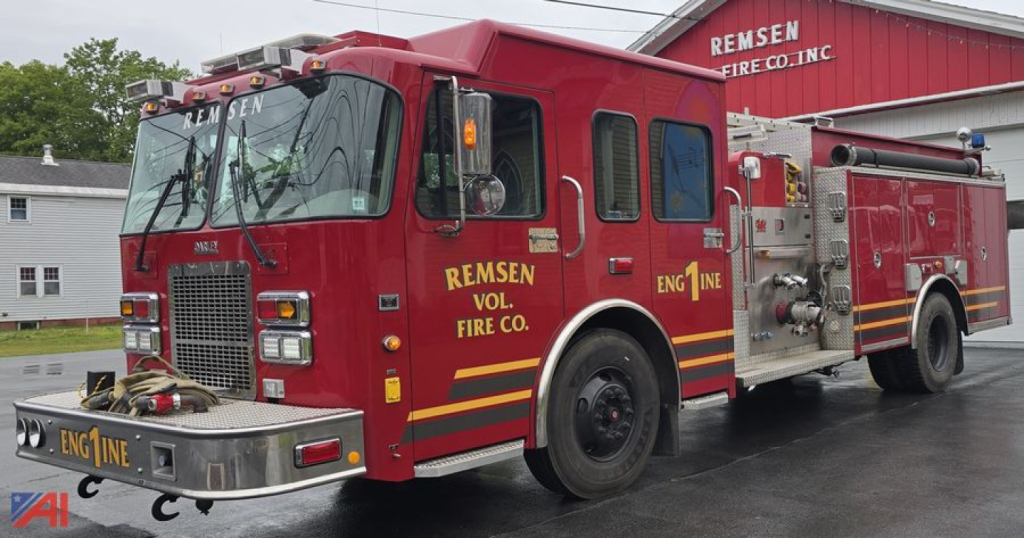 Fire engine truck showing front and side, red Spartan Darley pumper with 'REMSEN VOL. FIRE CO.' and 'ENG 1 NE' markings, hose bed and compartments visible.