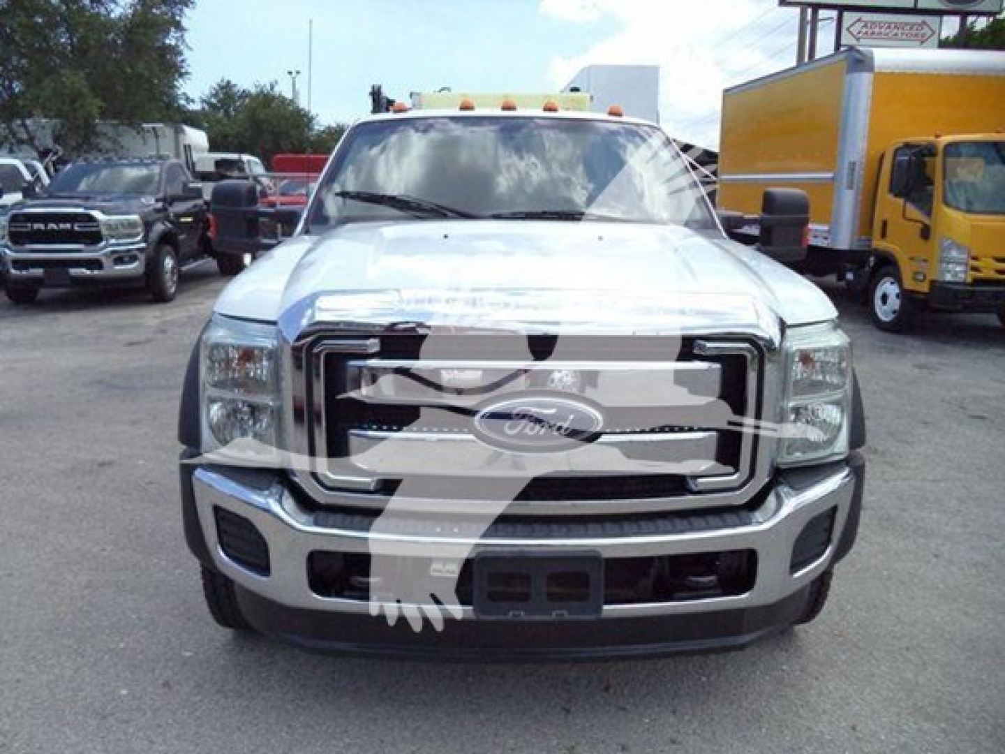 Front view of a white 2011 Ford F-450 XLT service truck showing large grille Ford emblem and bumper, with surrounding dealership lot.