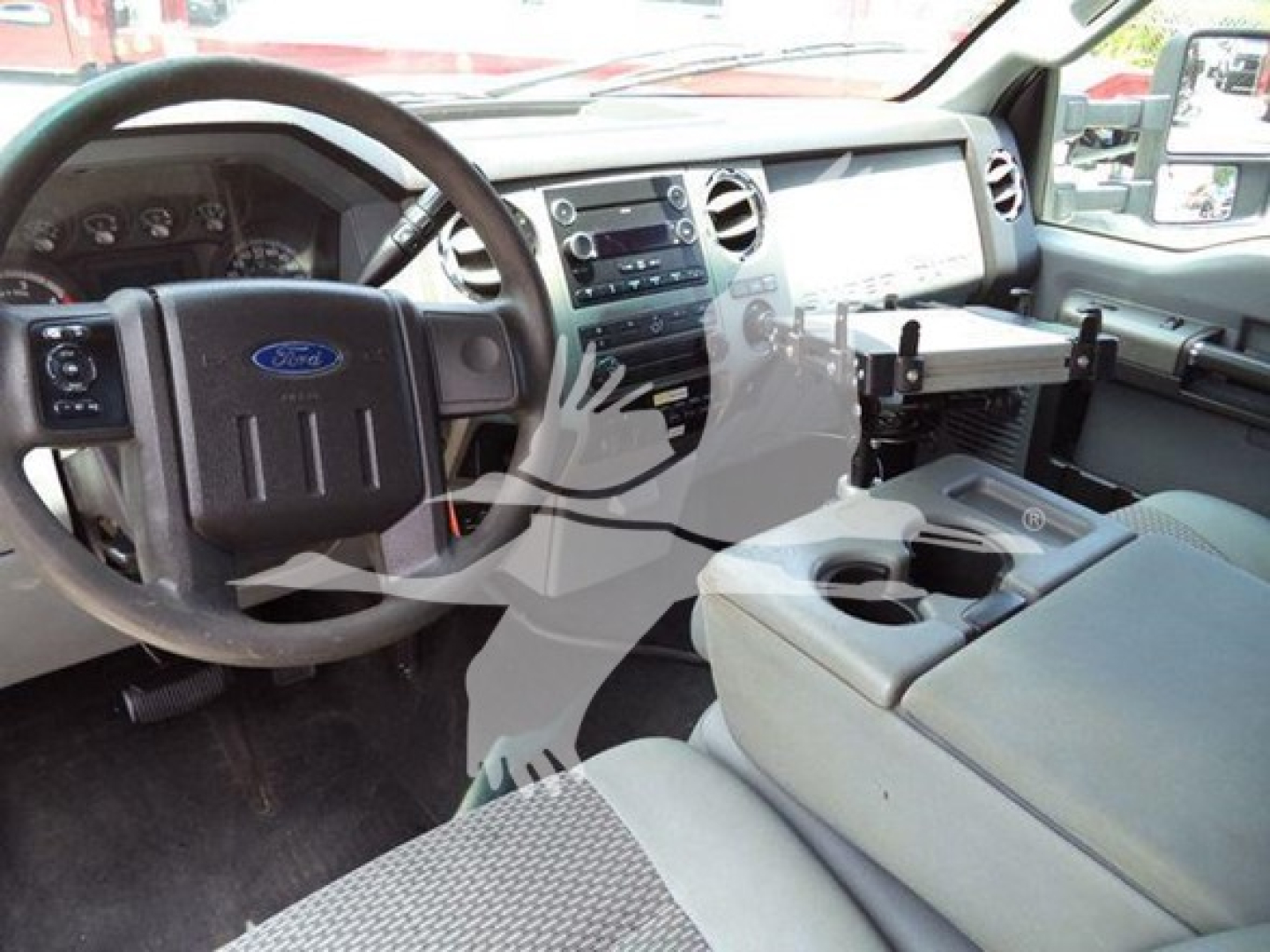 Ford F-450 interior dashboard and center console, steering wheel with Ford emblem, cup holders, and center storage area visible.
