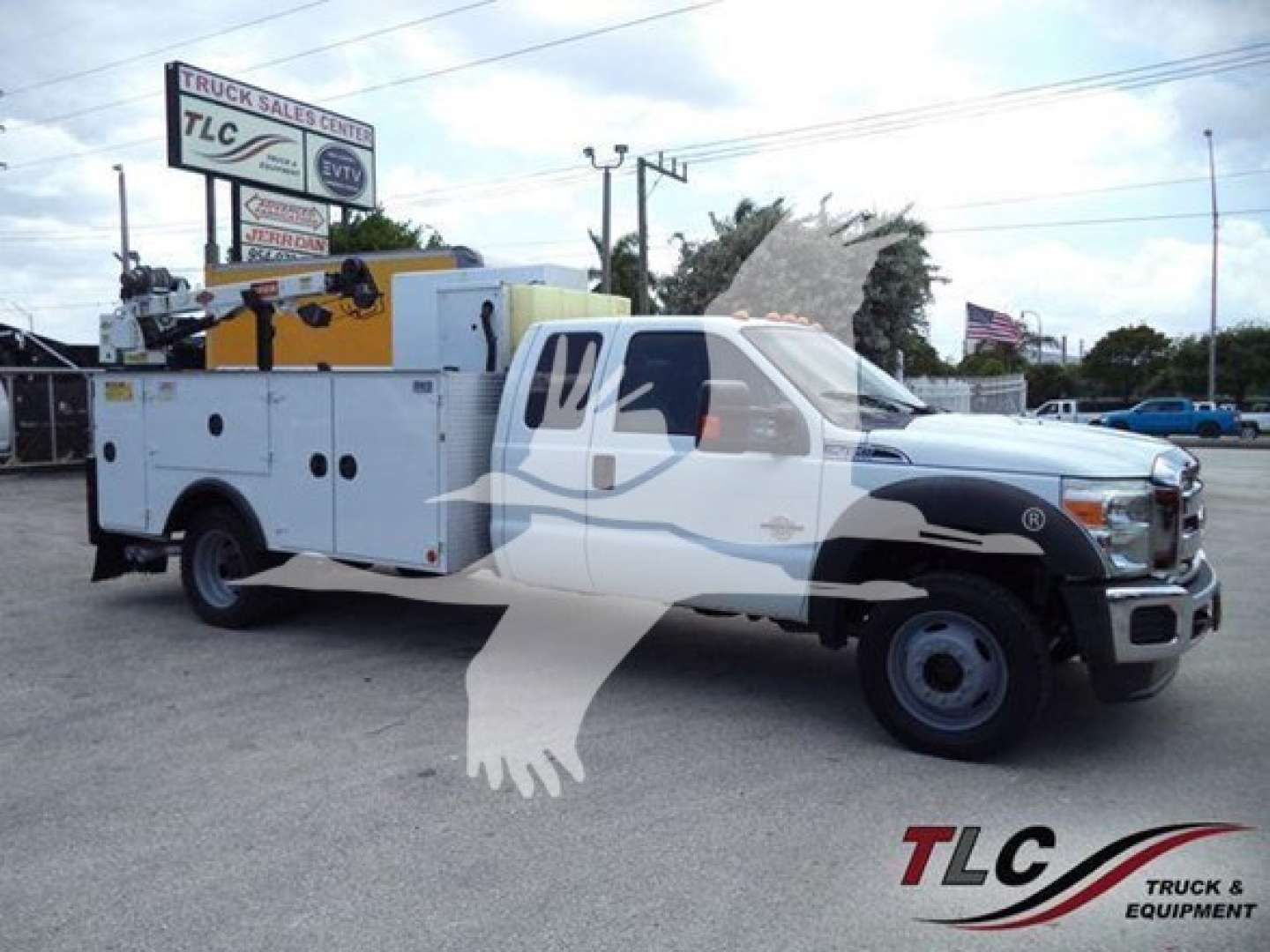 Ford F-450 utility service truck with ladder racks and utility compartments, white with black front fenders, logo watermark across image.