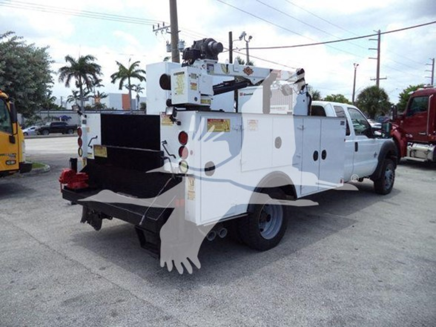 Ford F-450 service utility truck with mounted crane and utility compartments, rear view showing toolbox and equipment rack.