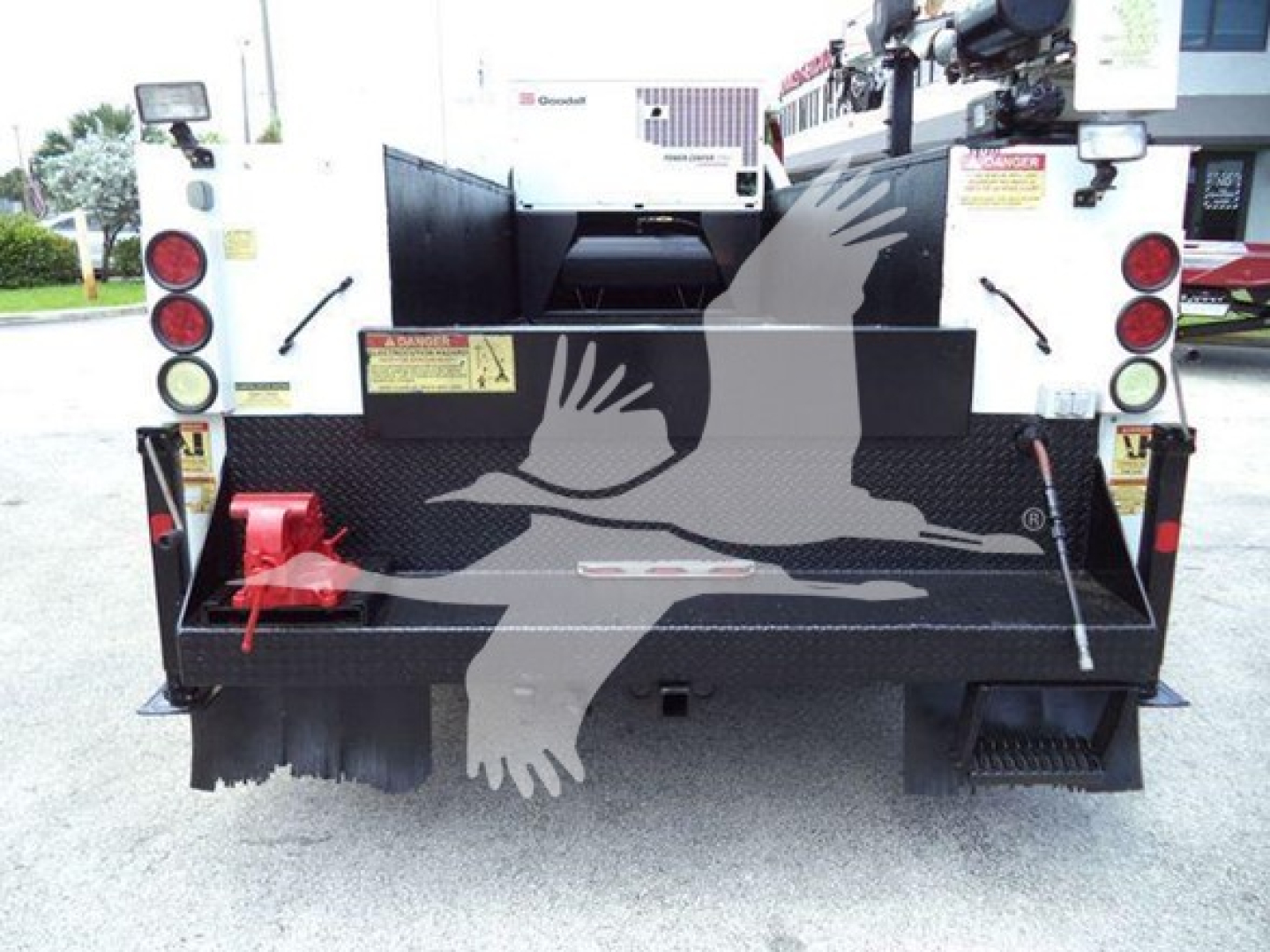 Rear view of a 2011 Ford F-450 XL T in-service trucks showing utility bed, tail lights, and rear bumper with step. Visible stickers and tool compartment access.