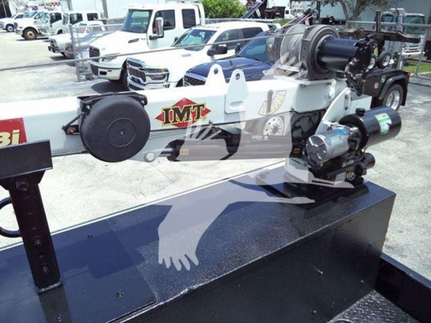 Industrial truck accessory mounted on a flatbed showing hydraulic winch and motor with IMT logo.