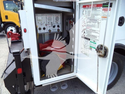 Service/utility truck engine bay with generator control panel visible and labels on the interior door.