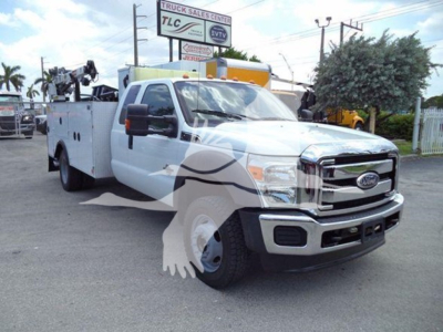 Ford F-450 utility service truck front-right view with utility bed and equipment on the back, 2011 model year.