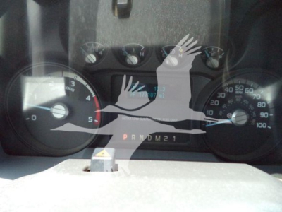 Dashboard view of a 2011 Ford F-450 showing speedometer and tachometer with gear indicator PRNDM21 and odometer reading."