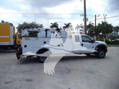 Ford F-450 service/utility truck with equipment racks and utility body, side view showing service compartments and workspace/storage rails.