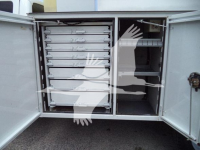 Ford F-450 utility truck rear showing multiple metal drawers and a storage compartment with shelves.