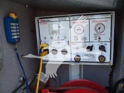 Service/Utility truck interior panel with controls labeled for engine coolant, AC power, and air compressor; shows gauges and switches.