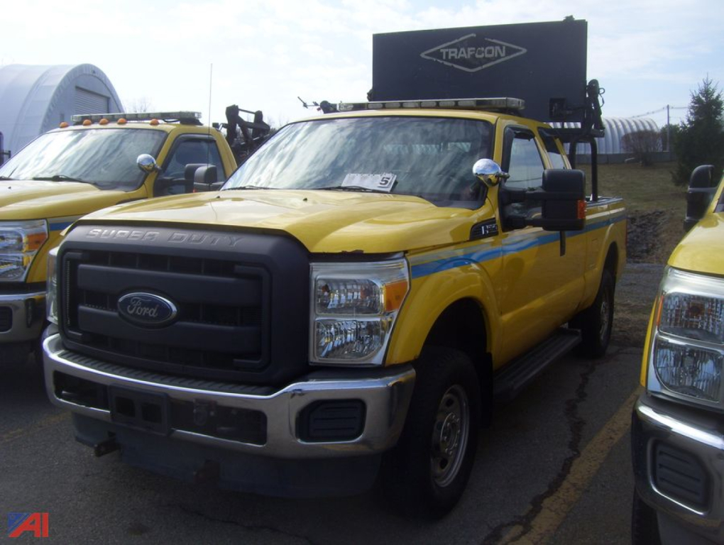Ford F-250 Super Duty pickup truck in yellow with service body, front grille and Ford emblem visible.
