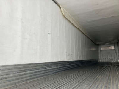 Trailer interior showing empty aluminum refrigerated trailer with ribbed floor and side walls.