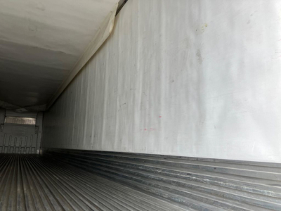 Trailer interior cargo area with insulated walls and ribbed metal floor.