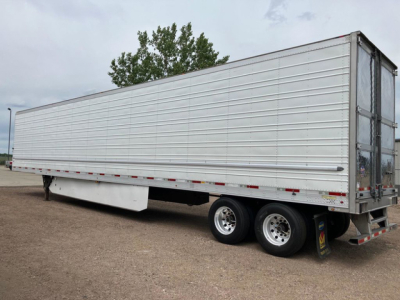 Trailer side view showing a 2020 utility refrigerated trailer with dual rear axles and silver aluminum paneling.