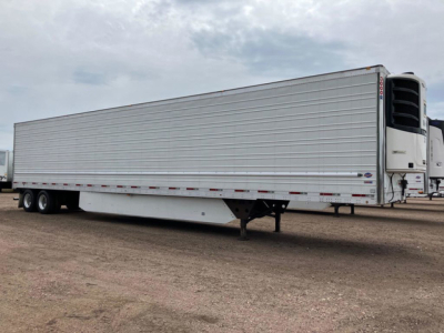 Trailer side view showing a 2020 utility reefer trailer with silver ribbed walls, refrigeration unit at front, tandem axles at rear, and landing gear visible.