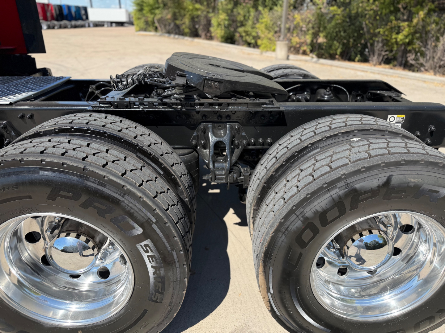 Kenworth/T680 rear axle area showing dual Goodyear tires with chrome rims and suspension components. No visible text objects readable besides tire sidewalls.