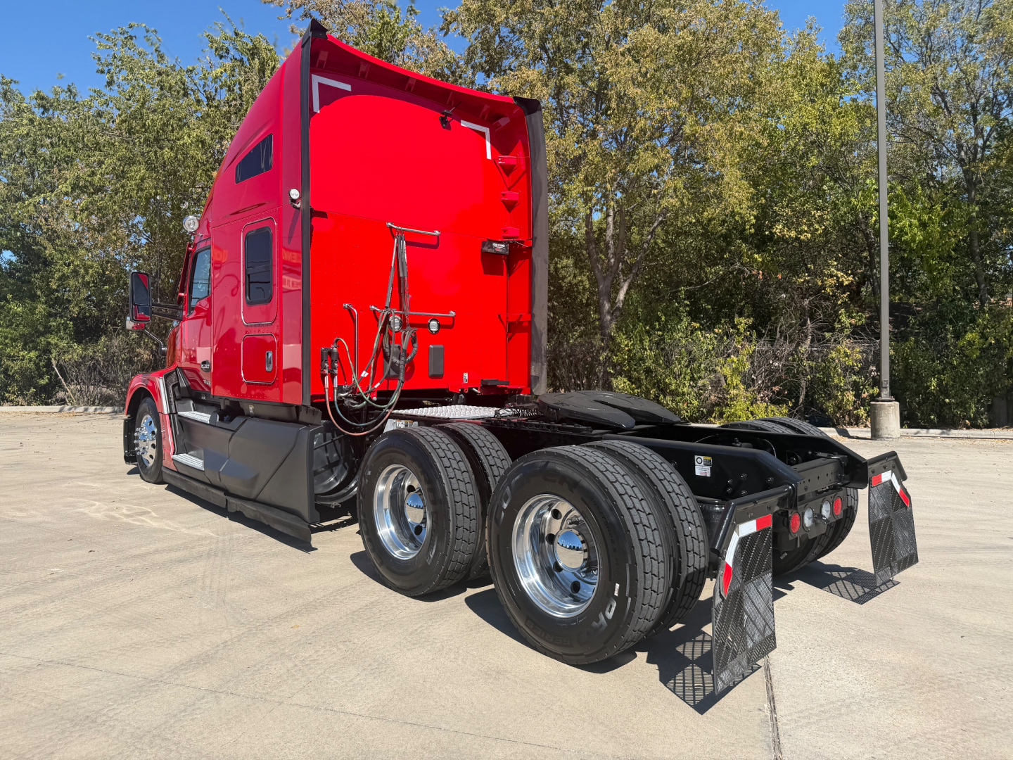 Kenworth T680 tractor rear/side view showing dual rear axles and red cab. No visible labels or text readable.