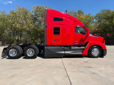 Red 2023 Kenworth T680 tractor truck side view showing sleeper cab and dual rear axles, with VIN/stock info not visible.