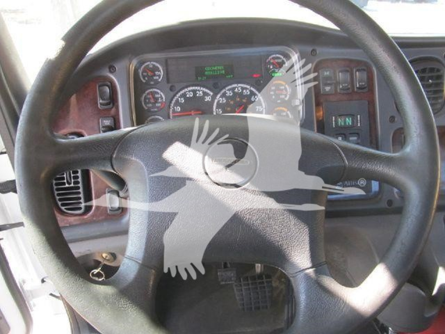 Steering wheel view of a Freightliner M2 106 dashboard with gauges and display panel; exposure shows truck controls and instrument cluster.