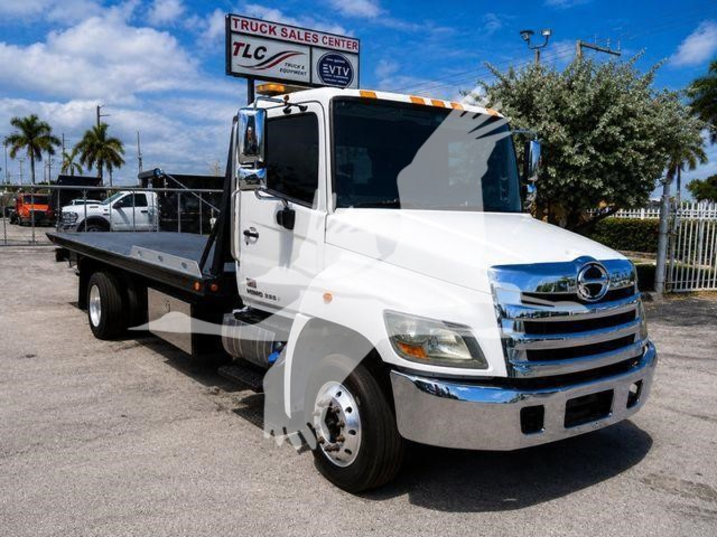 White 2020 Hino 258Alp rollback tow truck with flatbed, front chrome grille, and side mirror, VIN 5PVNJ8JN2L4S53930 visible in listing.