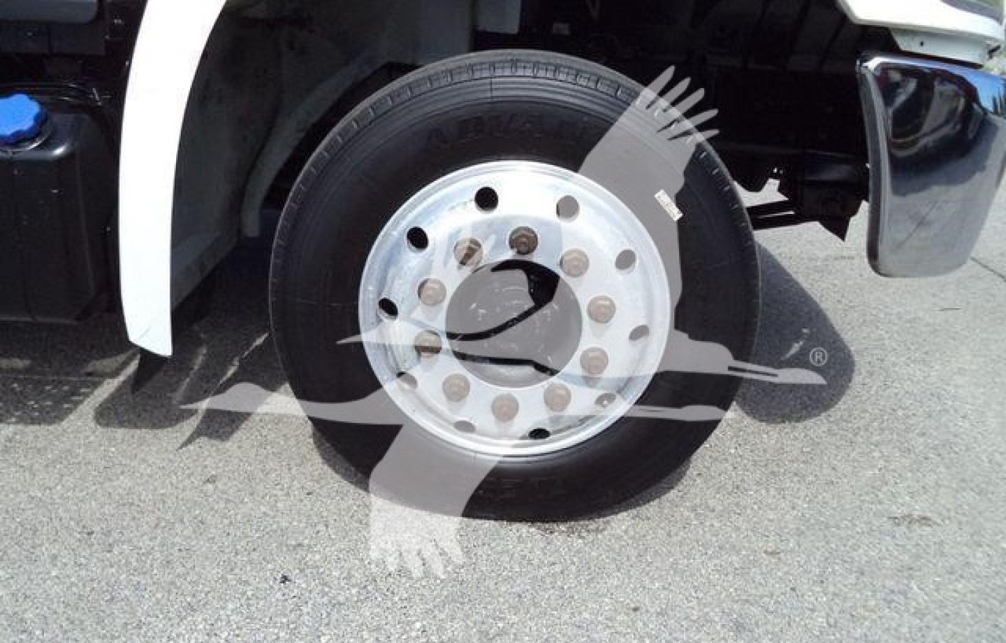 Front wheel and tire of a Hino truck showing polished aluminum rim and lug nuts.