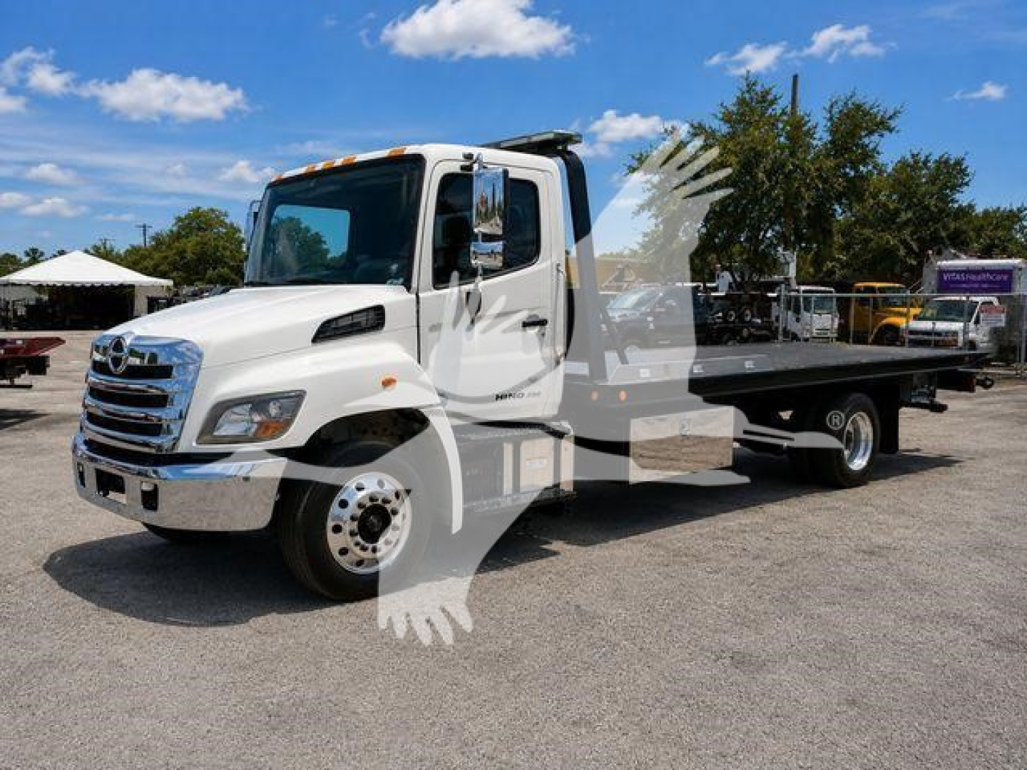 White 2020 Hino 258Al rollback tow truck, listing details visible in photo with VIN and stock number not shown on image.