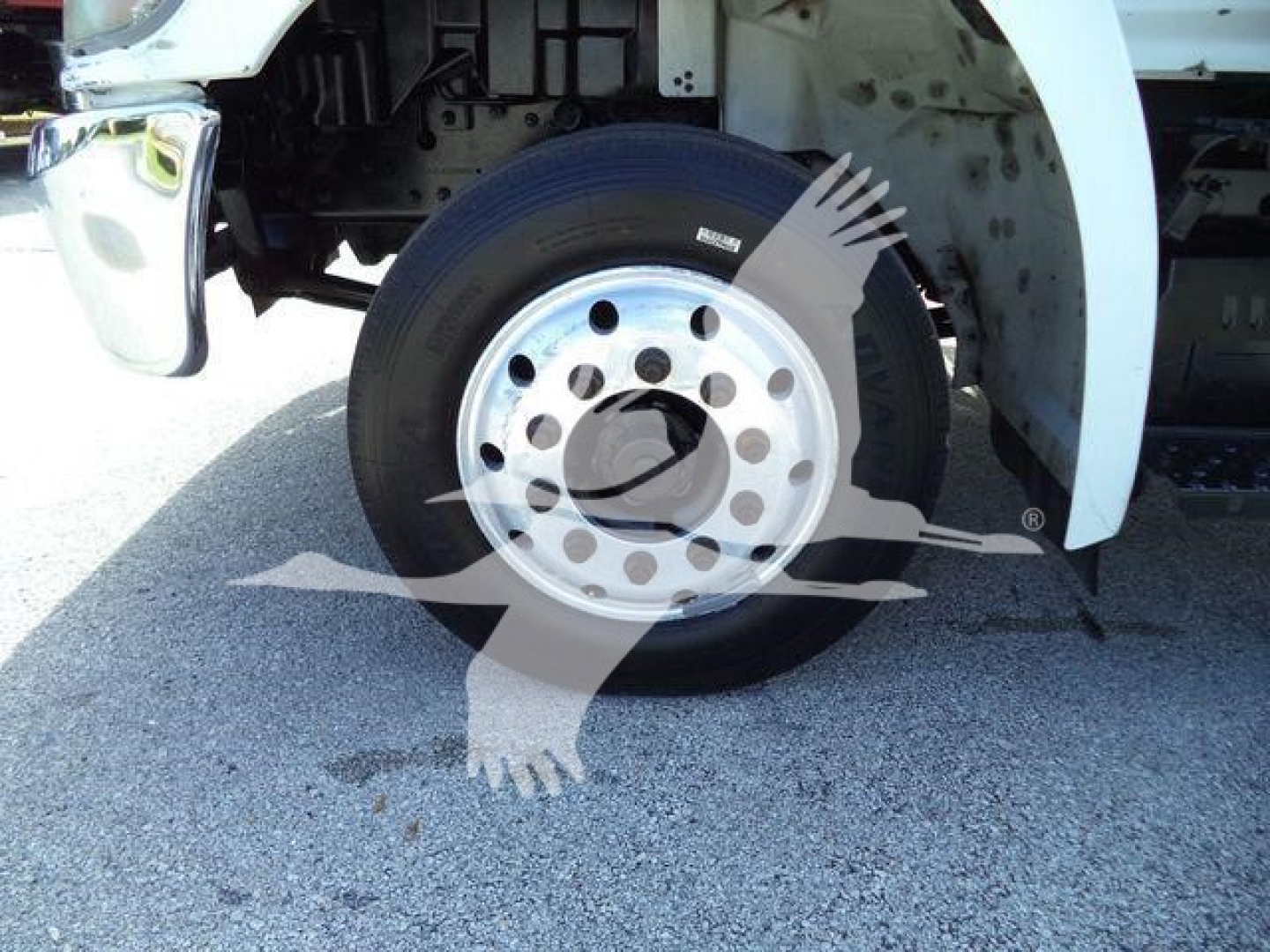 Truck wheel close-up with front fender and part of chassis visible; no legible labels apparent on tire or surrounding components.