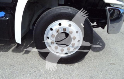 Front wheel and tire of a Hino truck showing polished aluminum rim and lug nuts.