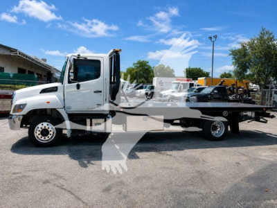 White Hino 258Al rollback tow truck side view with flatbed and winch, VIN 5PVNJ8JN2L4S53930 visible on listing sheet.