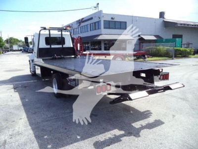 Flatbed tow truck rear view showing hydraulic rollback bed with loading ramps and rear lights.