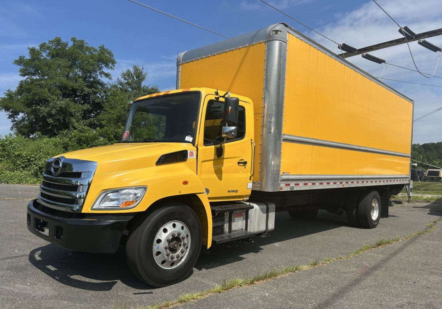 Truck with yellow cab and large yellow box cargo area, side view, Hino 338 model
