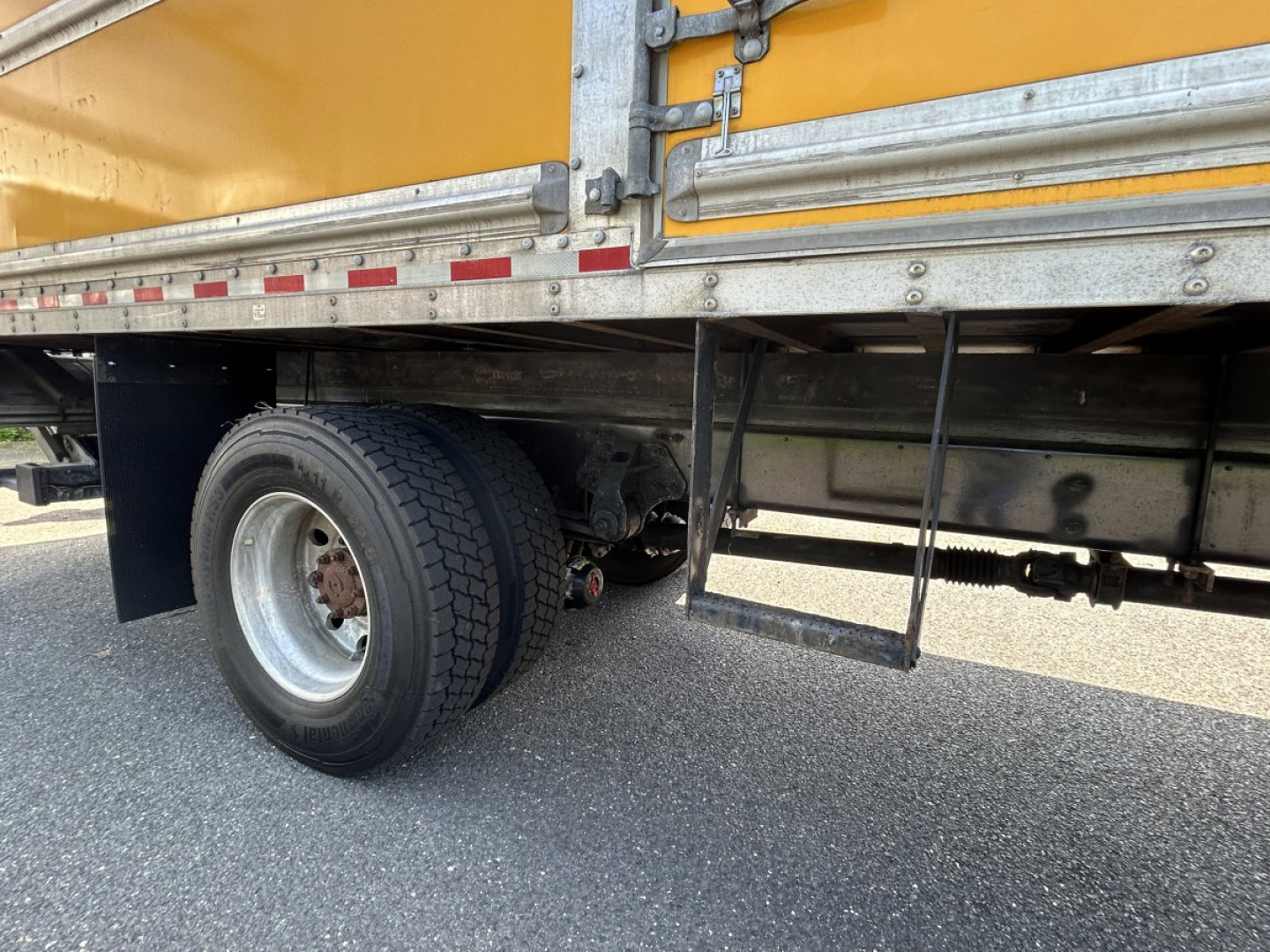 Hino 338 box truck rear wheel area showing dual rear wheels and undercarriage components