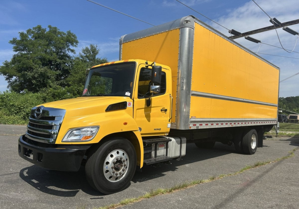 Truck with yellow cab and large yellow box cargo area, side view, Hino 338 model