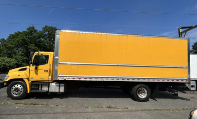 Box truck side view showing a yellow Hino 338 with a large orange cargo box and boxed trailer, stock number 8269T, VIN 5PVNV8JV5L4S59645.