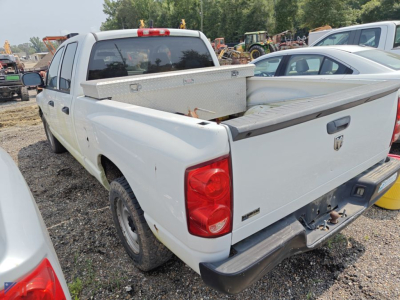 Rear-left view of a white 2008 Dodge Ram 1500 Crew Cab pickup with a diamond plate toolbox in the bed and a raised tailgate.