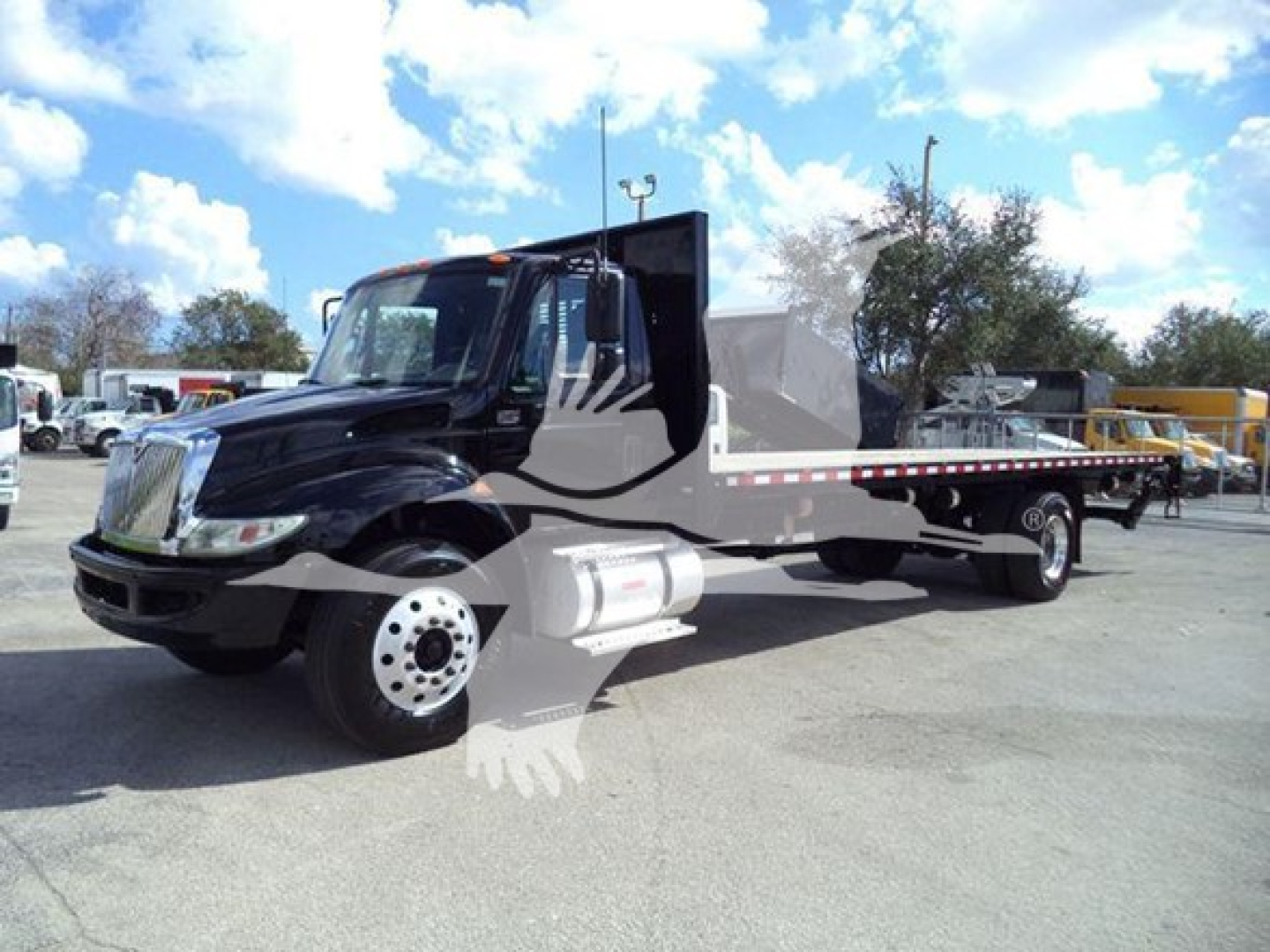 2019 International Durastar 4300 flatbed truck in a used condition, front-left view with a long equipment bed and chrome wheels.
