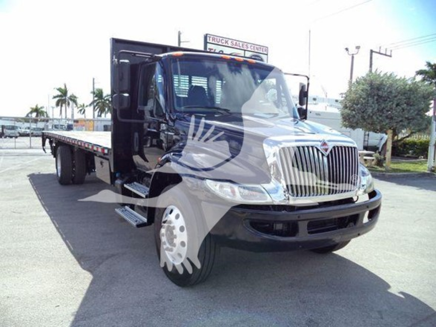 Truck cab and flatbed of a 2019 International Durastar 4300, side view with front grille, dual headlights, and flatbed extending to rear.