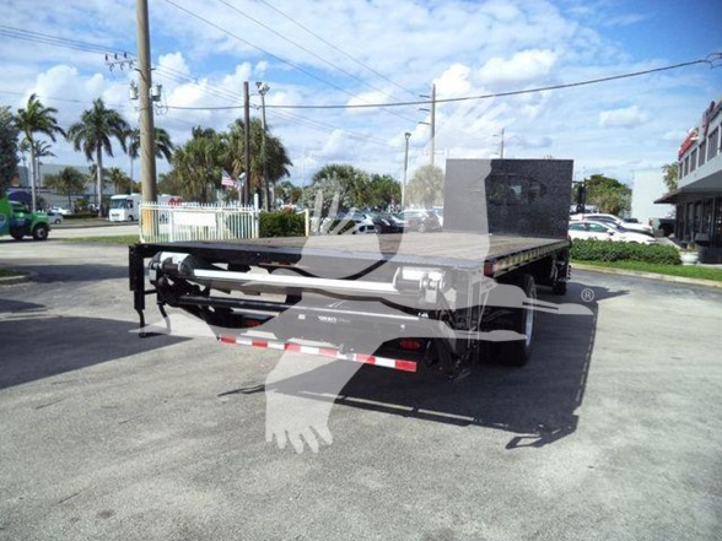 Flatbed tow truck body on a 2019 International Durastar 4300 viewed from rear-left side with flatbed and tail lights.