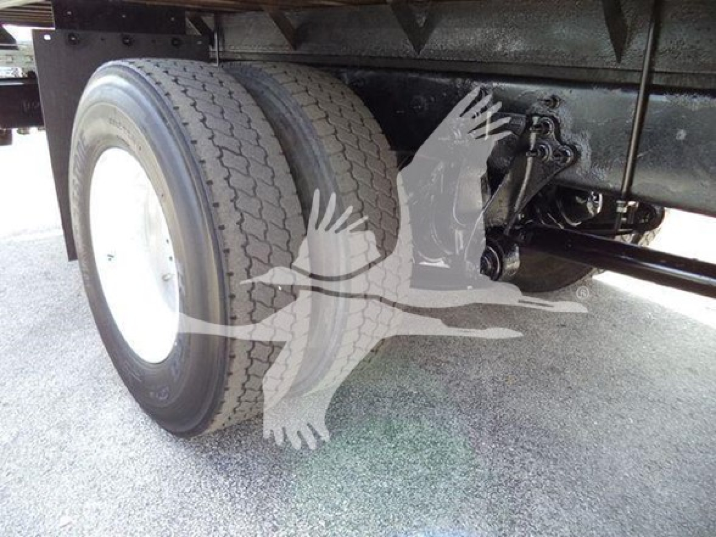 Truck rear axle with dual tires and suspension components visible under flatbed on International Durastar 4300