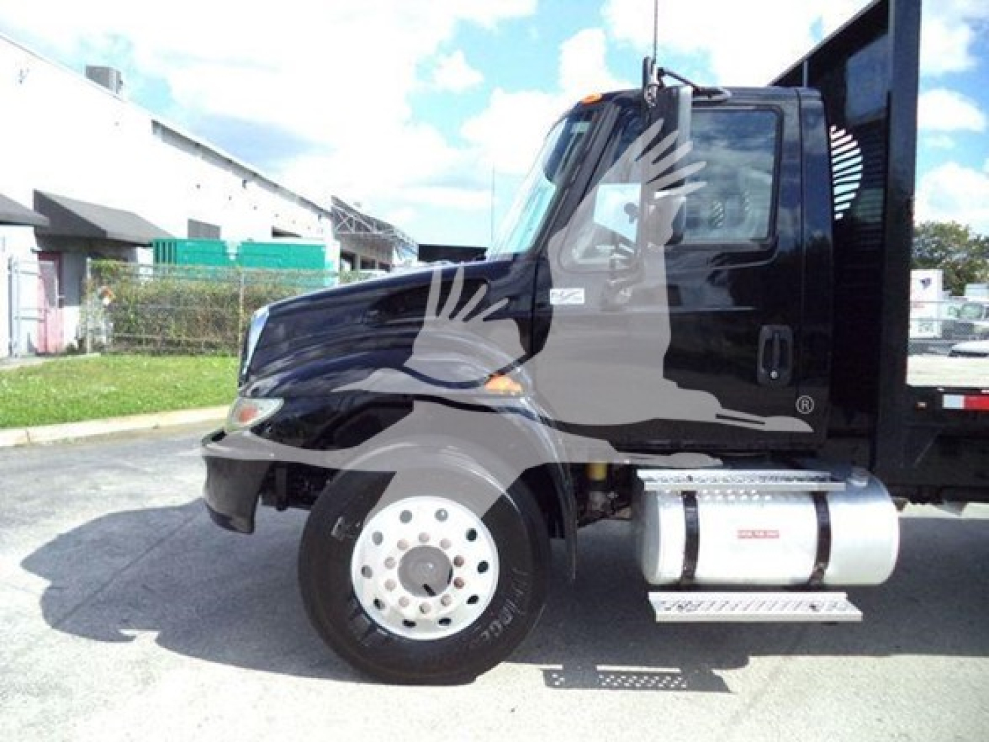 International Durastar 4300 truck side view showing black cab and silver fuel tank with steps.