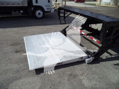 Flatbed truck accessory showing a hydraulic ramp and lifting mechanism with a metal platform extended.