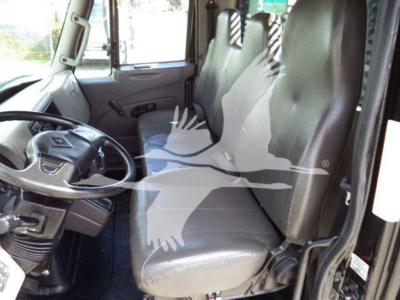 Interior of a 2019 International Durastar 4300 flatbed truck showing front seats, steering wheel, and dashboard. Visible VIN plate and doors.