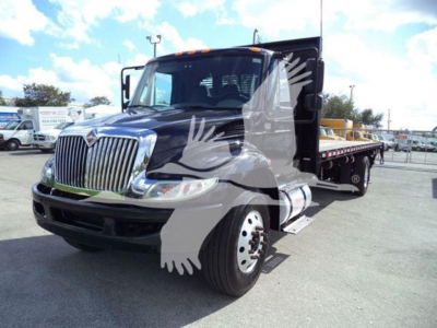 International Durastar 4300 flatbed truck in a dealership lot showing front grille and flatbed.