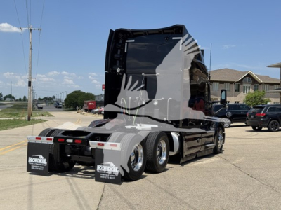Peterbilt 579 truck rear view showing sleeper and chassis with dual rear axles and mud flaps.