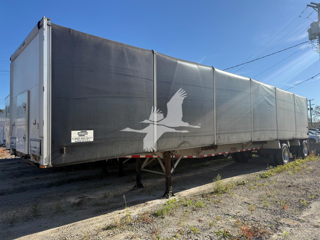 Curtainside trailer showing side silhouette artwork and multiple panels, with front and rear wheels and landing gear visible.