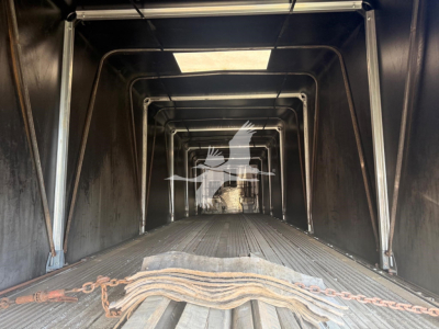 Trailer interior of a 2006 Reitnouer Maxmiser curtainside trailer showing the empty load deck with a chain and hook at the foreground and welded aluminum framing.