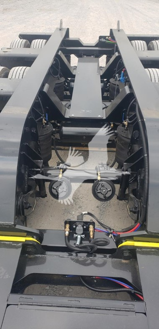 Trailer frame showing underside of Fontaine 55Mx lowboy with visible hitch, hydraulic lines, and wheel axles; VIN and stock labels not visible in this view.