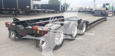  Fontaine lowboy trailer showing long multi-axle flatbed with gooseneck and rear wheels; black frame with taillights and reflectors