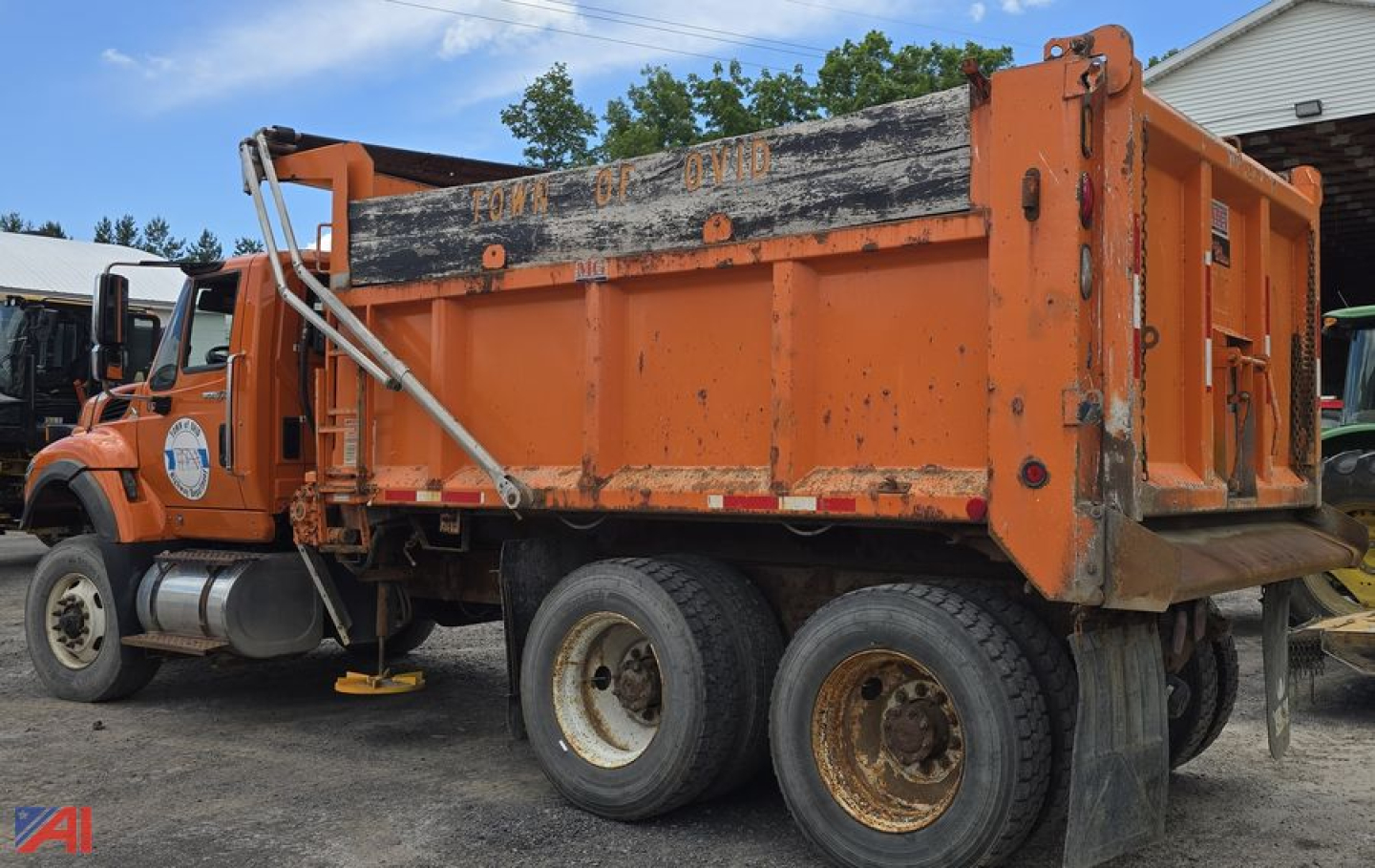International WorkStar 7600 dump truck with plow showing orange body and dual rear axles.
