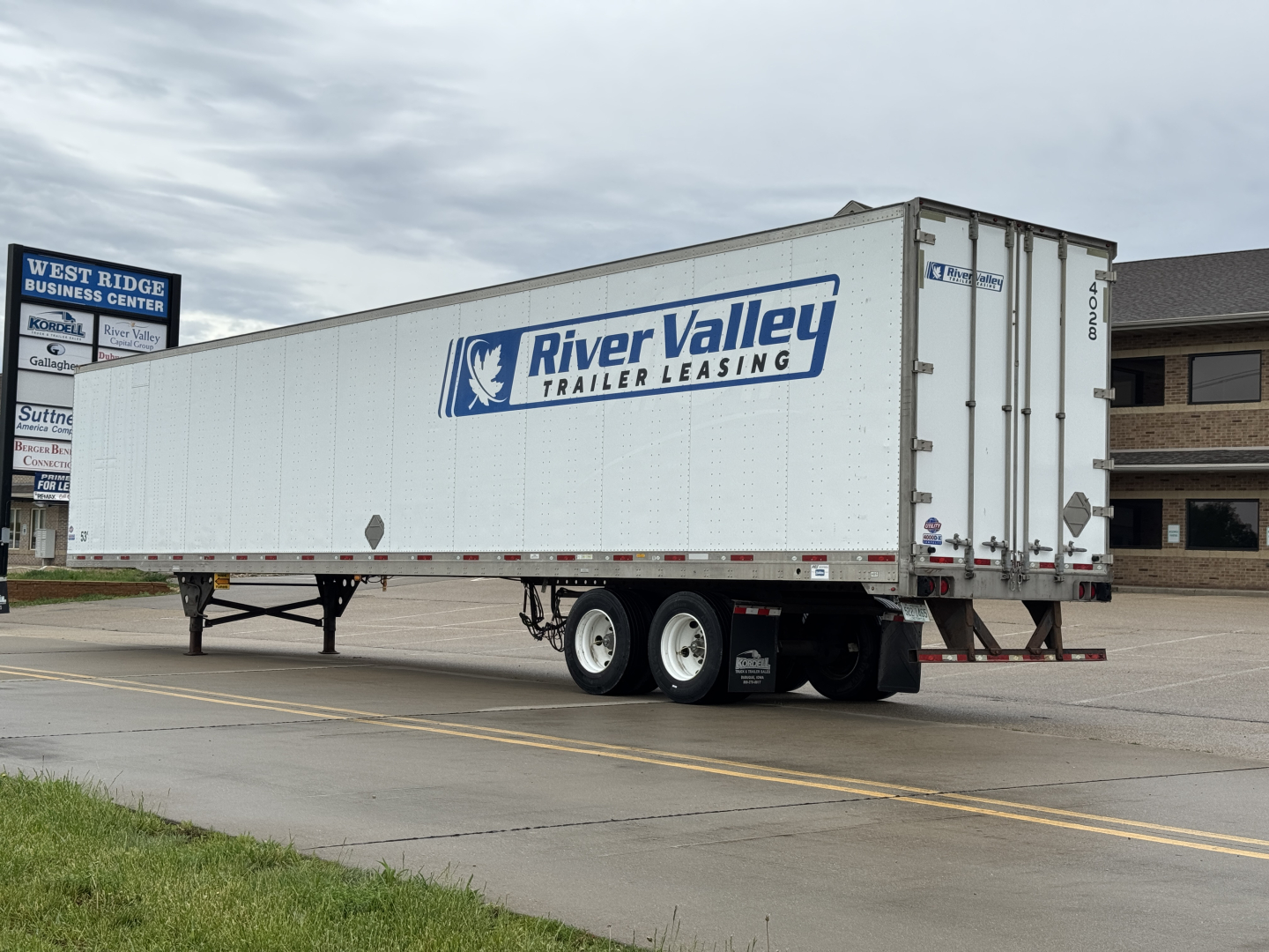 Trailer side view showing River Valley Trailer Leasing logo on a long white cargo trailer with dual rear doors and tandem axle.